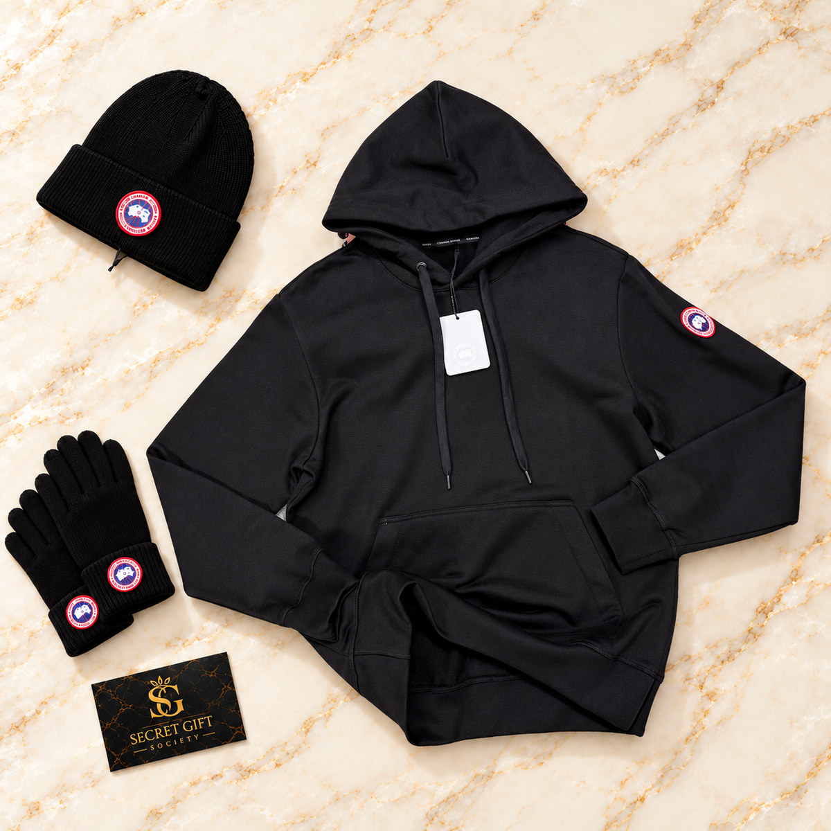 Black CG logo hoodie on ivory marble with matching hat and gloves and a Secret Gift Society card