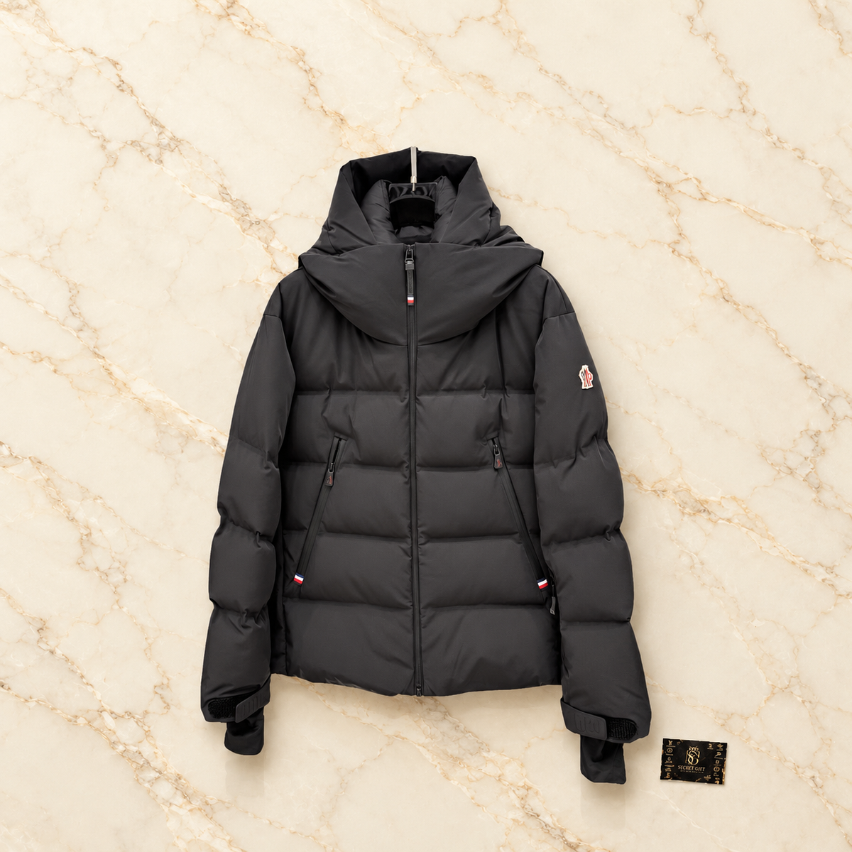 MNCLR GRENOBLE SKI COAT - BLACK on ivory marble with Secret Gift Society card